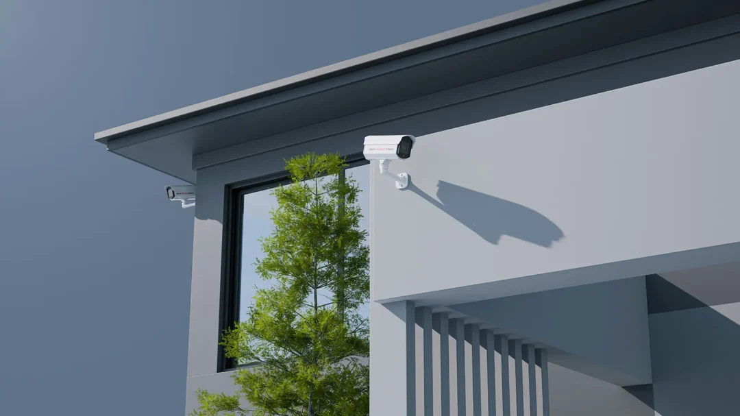 Two modern white security cameras mounted on a sleek grey building exterior, representing the advanced safety solutions and the 372% increase in goal completions Repeat Digital delivered for Comprehensive Fire & Security.