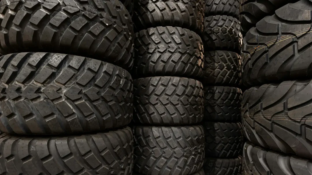 A warehouse wall of stacked, high-tread vehicle tyres, representing the extensive inventory and 10% increase in sales Repeat Digital delivered for MyTyres.