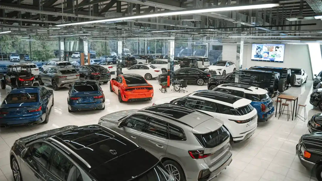 A large, modern car showroom filled with various vehicles, representing Repeat Digital's expertise in automotive marketing and dealership lead generation.