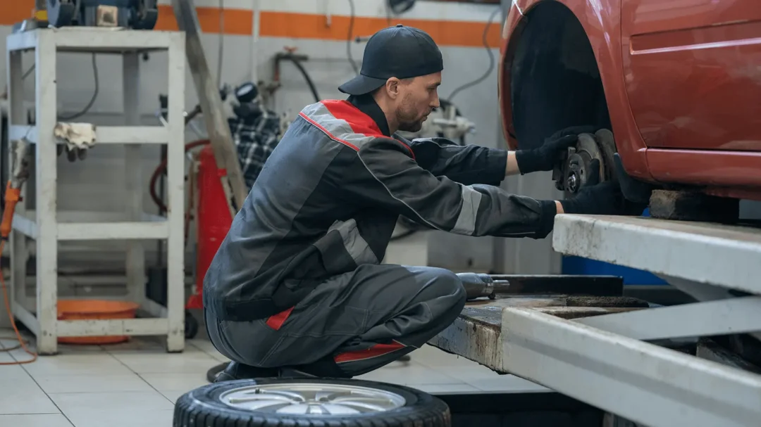 A mechanic in a workshop performing a vehicle service, representing Repeat Digital’s expertise in driving aftersales and MOT leads for automotive businesses.