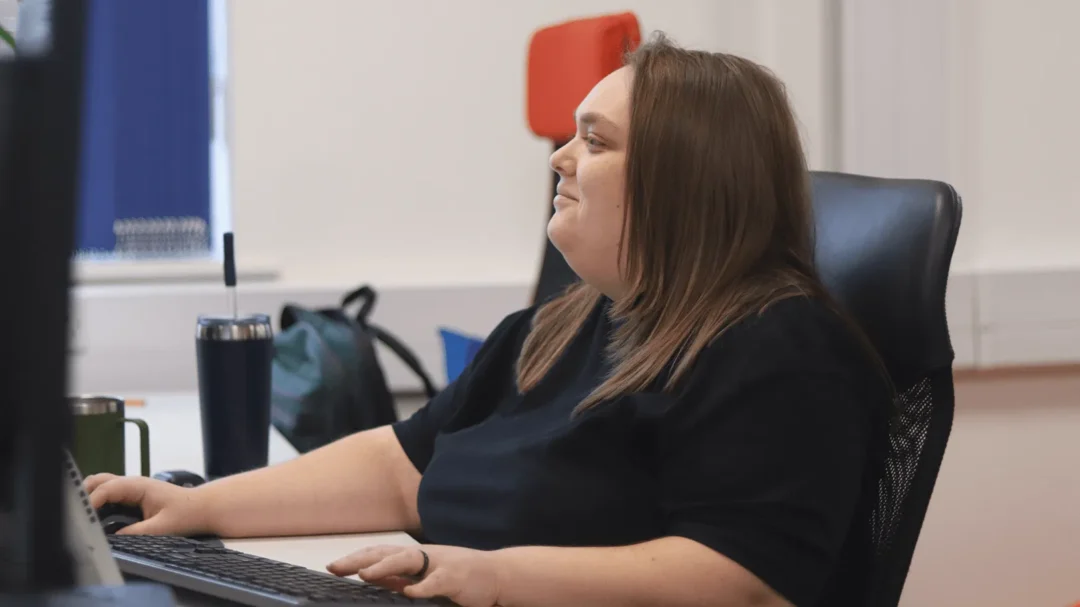 A digital marketing specialist at Repeat Digital working on a computer in a bright, modern office setting.