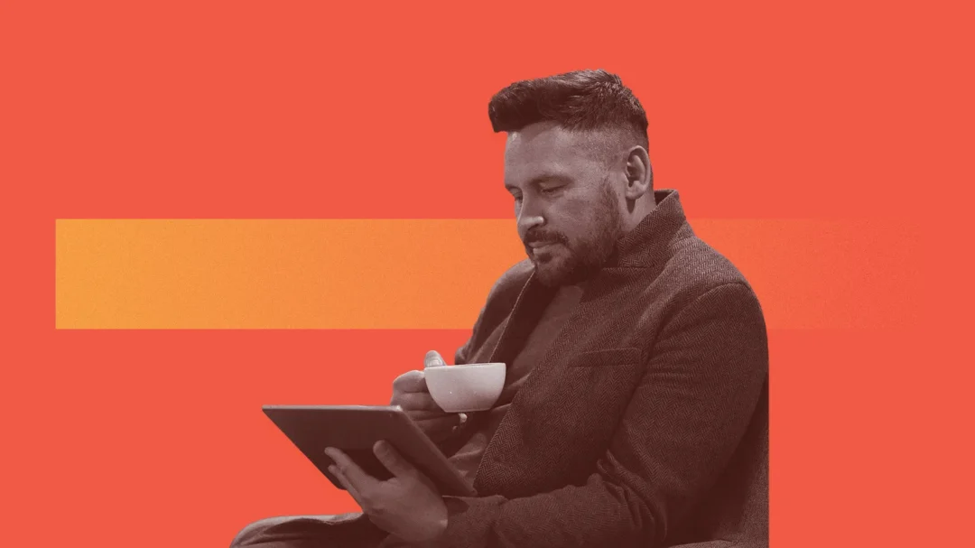 A professional in a blazer reviewing local search performance on a tablet while having coffee, symbolising a strategic approach to local business growth.