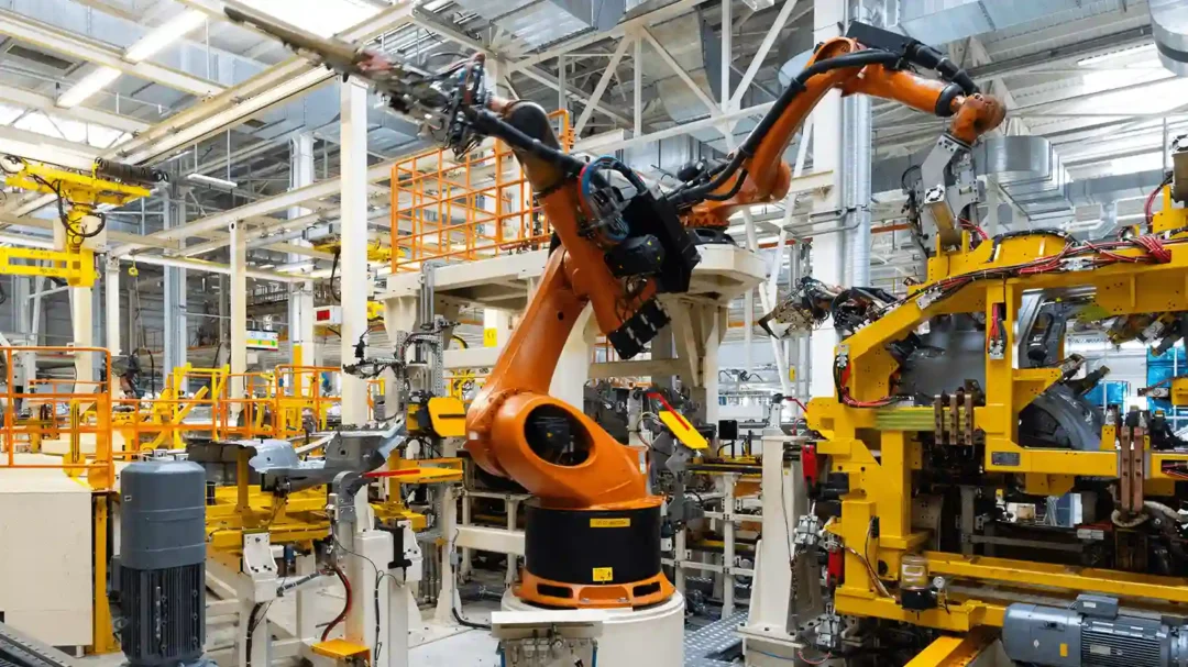 An advanced industrial production line featuring robotic arms in a modern factory, representing Repeat Digital's expertise in marketing for automated manufacturing brands.