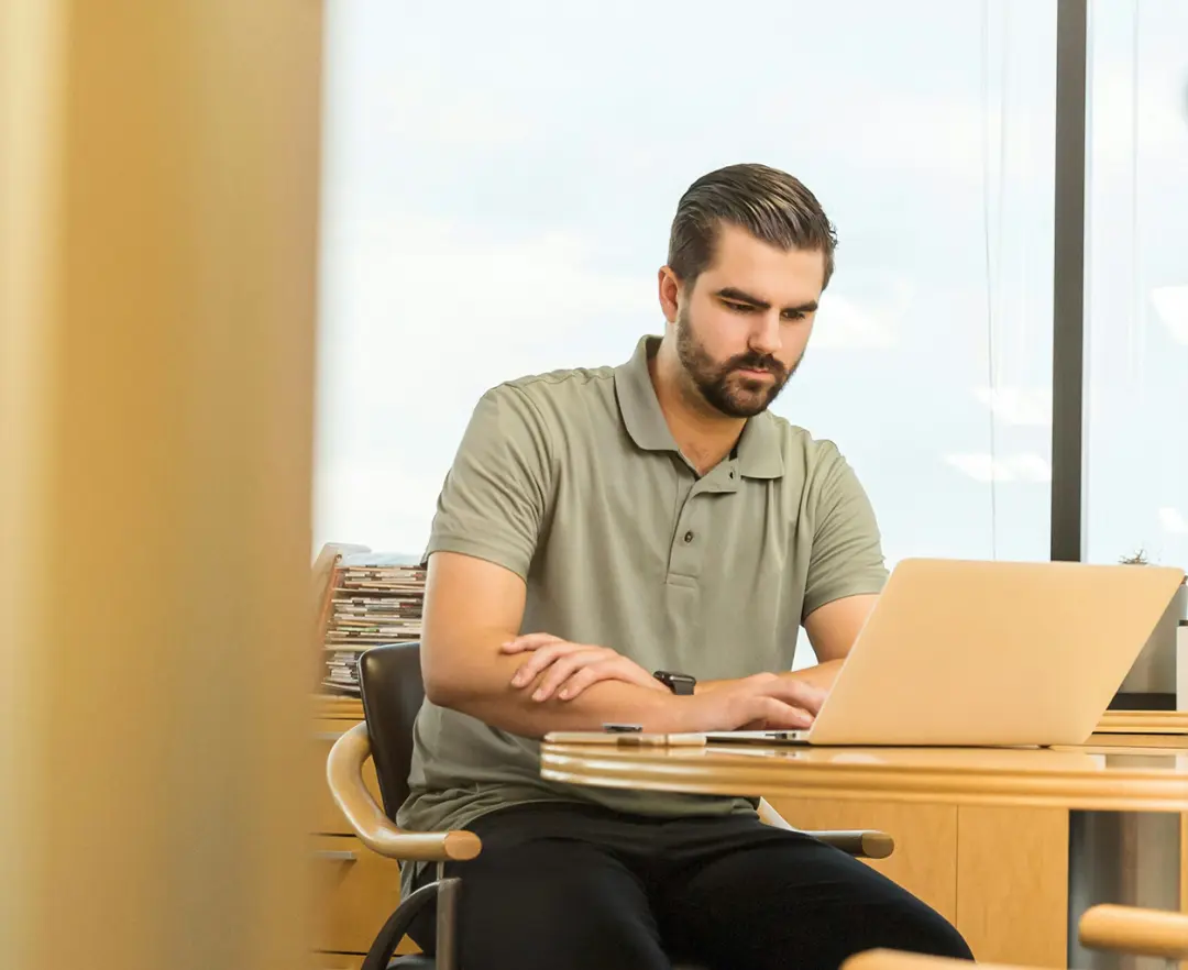 Sam Rawson 11 Man sitting typing on a laptop