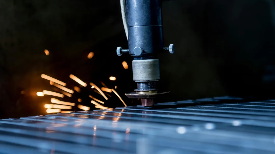 Close-up of an industrial laser cutting through metal with sparks flying, representing digital marketing expertise for the manufacturing sector.